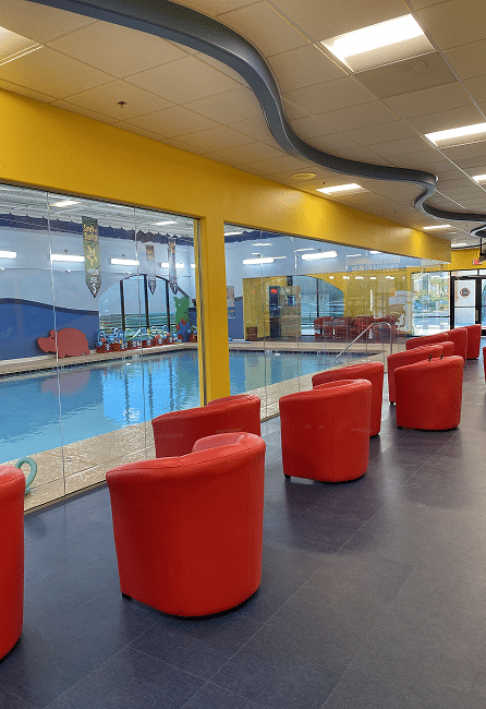 Red chairs by indoor swimming pool